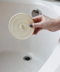 Person placing 5 Inch Flat Suction Rubber Sink Stopper Fits Most Kitchen And Bathroom Sinks And Tub Drains White Durable Rubber into drain.