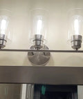 Three Light Bathroom Vanity Light Fixture In Brushed Nickel With Clear Glass Shades Over Mirror Wall Sconce Easy To Install
