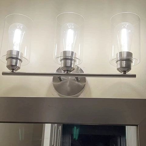 Three Light Bathroom Vanity Light Fixture In Brushed Nickel With Clear Glass Shades Over Mirror Wall Sconce Easy To Install