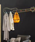Modern Wall Mount Coat Hooks Dang Handy Entryway Storage Rack Easily Hangs Coats Jackets And Keys With Heavy Duty Steel Frame Built For Everyday Grind At Home, styled like a guitar with coats and a backpack.