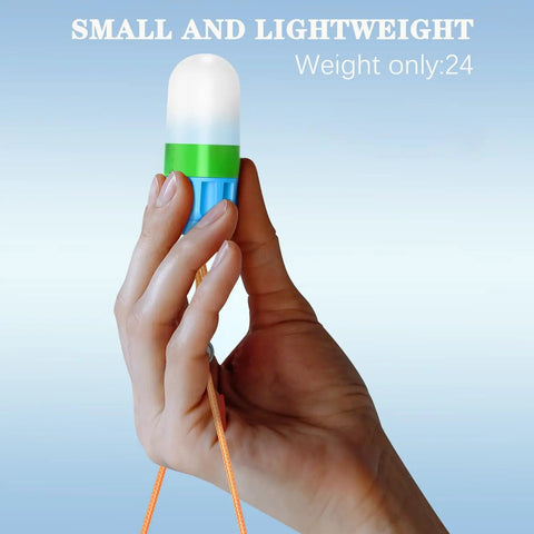 Hand holding small blue and green Underwater Signal Light For Diving IPX8 Submersible Beacon With Constant And Flashing Modes.