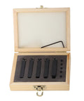 Front view: open wooden box with five black carbide indexable turning tools in foam insert.