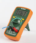 MiniTec Autoranging Digital Multimeter With 600V AC DC, 10A Current, Temperature, Resistance, Capacitance, Frequency, Continuity And Diode Testing, Includes Protective Holster And Tilt Stand in orange protective holster.