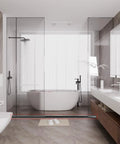 Slick Nifty 39 Inch Black Shower Threshold Water Dam Stopper in modern bathroom with glass shower and freestanding tub.