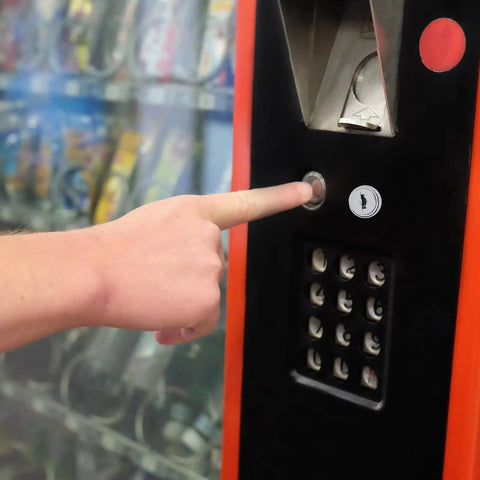 Secure Your Setup With This Sick Black Metal Vending Machine Lock Assembly With Tubular Keys For Snack Candy Dispensers Ensuring Quick Fixes And No Sweat Maintenance To Keep Your Stock Safe And Business Rolling Smoothly Right Now. Black metal vending machine lock on snack dispenser panel, with finger pressing the lock.