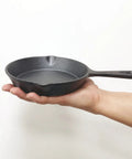 Hand holding Six Inch Cast Iron Skillet With Drip Spouts For Even Heat, Preseasoned Oven Safe Frying Pan