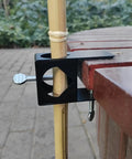 Go To Pole Holder Deck Mount Clamp Set For Tiki Torches And Mounting Poles On Porch Table Deck Or Fence Four Pack Heavy Duty Outdoor Clips For Lighting Bird Feeders And Flags installed on outdoor bench holding pole securely