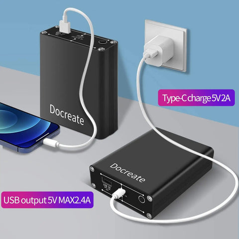 Portable metal power bank with USB and Type-C charging ports connected to phone and wall socket.