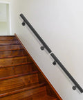 Rock Solid Wall Mounted Stair Handrail Crafted From Premium Black Stainless Steel features sleek cylindrical profile on wooden stairs.