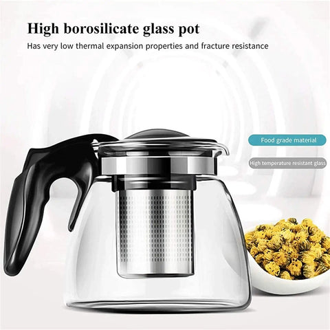 High borosilicate glass pot with black handle and metal infuser, next to a bowl of flowers, highlighting thermal resistance.
