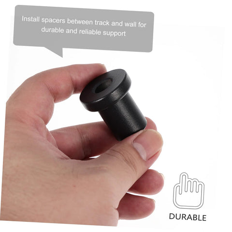 Hand holding a black carbon steel spacer from the 4 Piece Sliding Barn Door Track Spacers Replacement Carbon Steel Connector Hardware Kit.