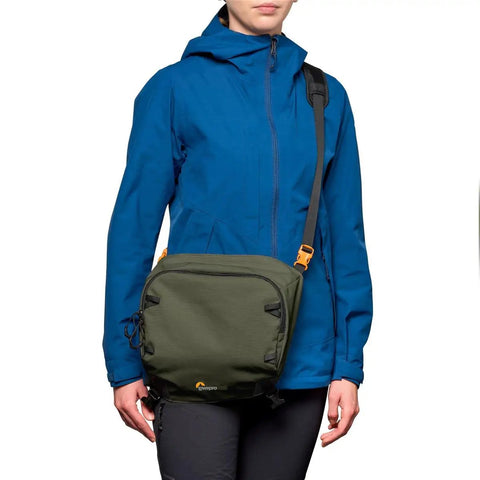 Person wearing green PhotoSport Pro 55L AW IV Camera Backpack For Mirrorless And DSLR Gear Medium To Large, over shoulder