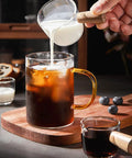 Single Spout Espresso Shot Glass With Wood Handle Measuring Cup Set, 75 Ml Two Pack pouring milk into coffee