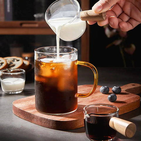 Single Spout Espresso Shot Glass With Wood Handle Measuring Cup Set, 75 Ml Two Pack pouring milk into coffee
