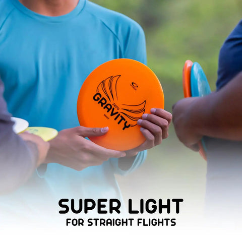 Person holding orange disc from Gravity Disc Golf Starter Set with Pure Fuse Explorer Saint Diamond Bolt, lightweight plastic for beginners.
