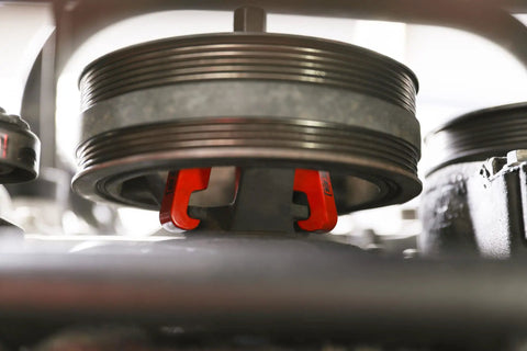 Harmonic Balancer Puller Kit for Cars and Trucks with Adjustable 3-Jaw Design in use on engine pulley.