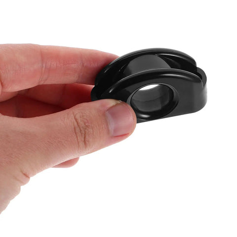 Hand holding a Pair Of Large Nylon Kayak Pulley with Rolling Bearings, black color, for smooth wire guidance on boats and kayaks.