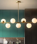 Groovy Mid Century Modern Pendant Light Set Featuring Sleek Glass Globes and Gold Finish with six round glass bulbs.