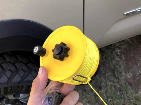 Hand holding Stiff UHMWPE Spearfishing Reel Line 175ft 1.9mm 680lb Load, Double Jacketed Shooting Line, yellow spool