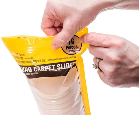 Hand opening package of Carpet Furniture Sliders Three Point Five Inch Round 16 Pack Make It A Breeze To Glide Heavy Sofas And Chairs