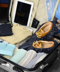 Reusable Boot And Shoe Covers For Real Estate Pros Water Resistant Non Skid And Washable To Keep Floors Carpets Footwear And Rooms Clean On The Job 2 Pairs Large Black inside a suitcase with folded clothes.