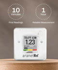 Portable Home Radon Detector With 10 Minute Readings, displaying radon level, temperature, humidity, E Ink display, on brown stand.