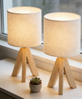 Set Of 2 Wood Tripod Bedside Lamps With Linen Fabric Shade on a windowsill