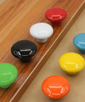 Total Room Glow Up With Durable Yellow Ceramic Round Cabinet Knobs And Easy Grip Handles Perfect For Dressers Kitchens Closets And Cupboards showing colorful ceramic knobs on wood.