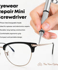 Eyewear Repair Mini Screwdriver held over black glasses, compact design for quick repairs, part of Fresh Eyes On The Go Lens Cleaning And Repair Kit.