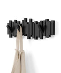 Sticks Wall Mounted Coat Rack With Five Retractable Pegs For Entryway Bedroom Or Office A Modern Space Saving Storage Organizer That Holds Hats Coats Bags And Clothes In A Slick Black Finish with two bags hanging from pegs