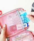 Close-up of pink mini outdoor first aid kit bag for travel and everyday use with handy pockets, showing interior compartments.