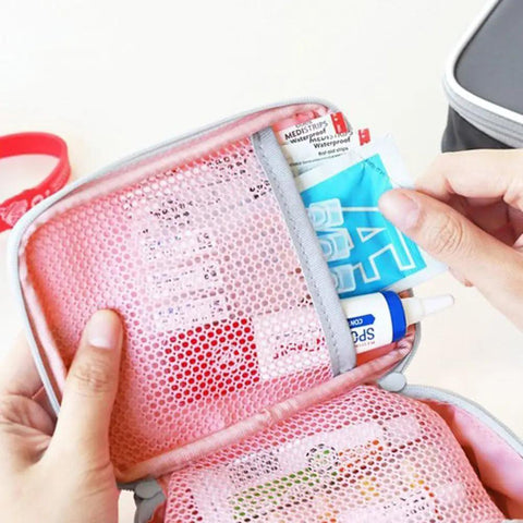 Close-up of pink mini outdoor first aid kit bag for travel and everyday use with handy pockets, showing interior compartments.