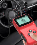 Universal OBD2 Code Reader And Diagnostic Tool with crisp LCD screen in hand inside a car, showcasing sturdy design.