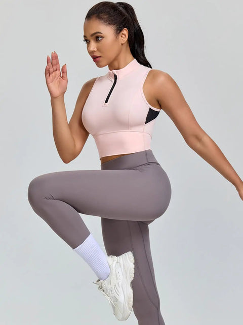 Woman exercising in cropped workout tank for women with built in bra half zip high neck sports top medium support sleeveless gym gear in Chintz Rose
