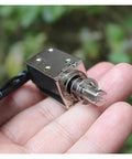 Hand holding DC 24V Linear Push Pull Solenoid Electromagnet Open Frame with 10mm Stroke Plunger for precise actuation