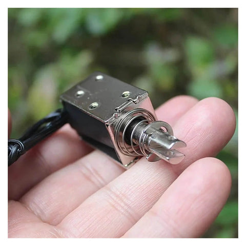 Person holding 24V Linear Push Pull Solenoid Electromagnet Open Frame Rugged Workhorse Actuator with 10mm Stroke Plunger for Automation