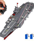 High Speed 16 Inch Warship RC Boat With Dual Rechargeable Batteries, 15 MPH Remote Control Battleship Aircraft Carrier For Pool And Lake, DIY Customization Gift For Boys Aged 8-12, shown with remote and batteries.