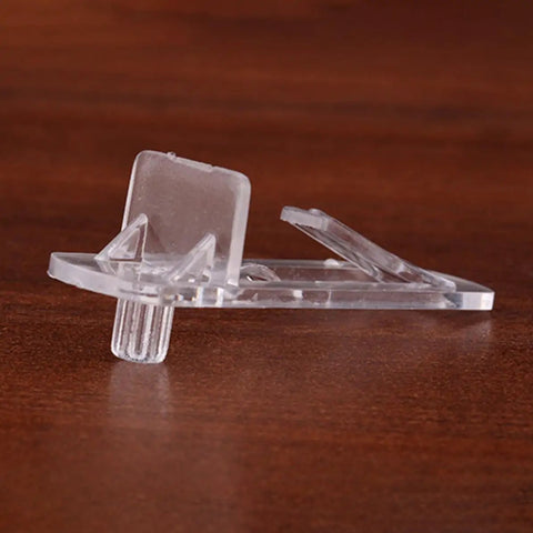 Close-up of a clear plastic shelf support peg for 15mm to 16mm wood shelves, rugged deformation-resistant pin, side view on wooden surface.