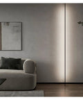 Effortlessly Sleek Modern Linear LED Wall Sconces With Remote Control For Cozy Bedroom And Living Room Vibes A Total Game Changer For Your Glow Up In Black Finish Dimmable Lighting, installed beside a gray couch.