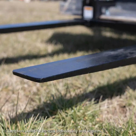 Close-up of Beefy 60 Inch Clamp On Pallet Forks for Loaders and Skid Steers, 47 Inch Long Forks by 4 Inch Wide in grass