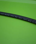 Close-up of premium #2 copper welding cable for Beefy Heavy Duty Battery Jumper Cables Set With Premium Copper Number 2 Welding Cable 12 Foot Length 500 Amp Clamps On Both Ends Red And Black Vehicle Jump Cables For Quick Starts And Emergency Power on green background showing cable marking."