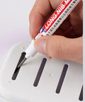 Person using Real Deal Deep Hole Marker Pens 15 Pack Black Ink Long Neck Markers on a slotted white surface.