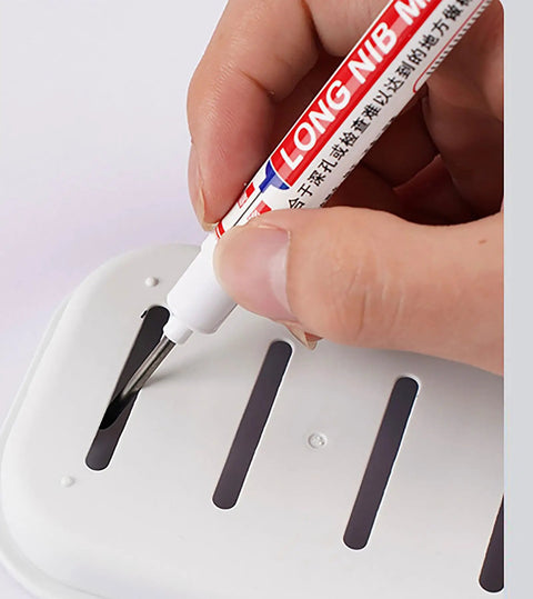 Person using Real Deal Deep Hole Marker Pens 15 Pack Black Ink Long Neck Markers on a slotted white surface.