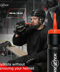 Hockey player using a 25 oz bio-based plastic sports bottle with long spout, orange cap, in locker room for fast hydration