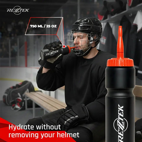 Hockey player using a 25 oz bio-based plastic sports bottle with long spout, orange cap, in locker room for fast hydration