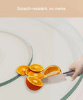 Hand slicing oranges on a round tempered glass spin turntable for dining tables with durable aluminum bearing perfect for shareable appetizers.