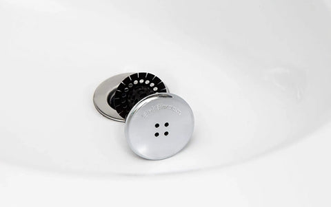 Sick Performance Bathroom Sink Drain Protector Hair Catcher With Universal Sink Stopper and Hella Tough Stainless Steel Strainer positioned in a sink.
