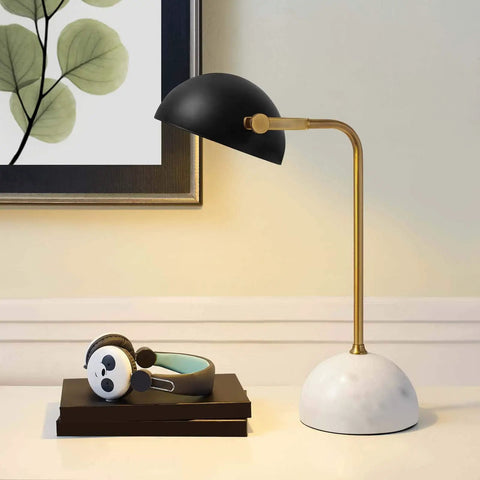 Bronze And White Marble Table Lamp With Half-Dome Faux Marble Base And Matte Black Metal Shade on a desk in a modern room