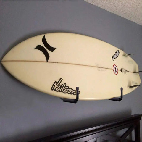 Surfboard mounted on wall using Heavy Duty 9 Inch Arm Wall Mount Storage Hooks Set With EVA Protector Indoor Outdoor Garage Hangers Organizer For Ladders Tools Bikes Hoses Gear And More 6 Pack.
