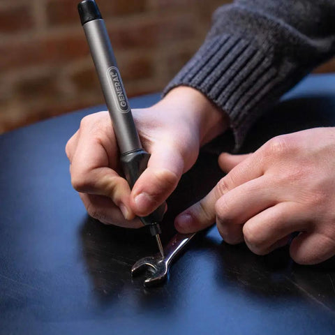 Person using Cordless Engraving Pen For Metal With Diamond Tip Etching Tool Dope For Toys, Sporting Goods on metal wrench